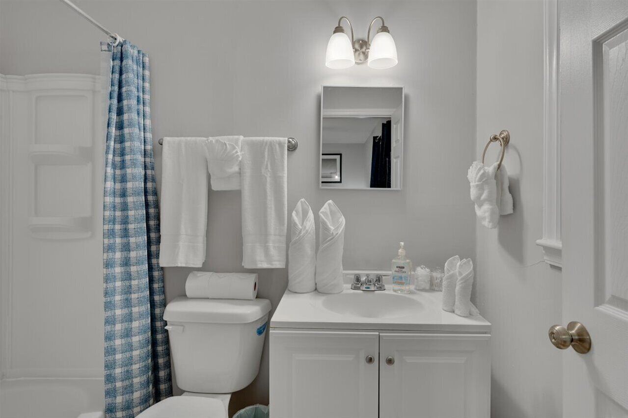 Een bad/douchecombinatie, handdoeken, zeep, toiletpapier