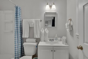 シャワー付き浴槽、タオル、石鹸、トイレットペーパー