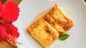 Do alimentos sobre um prato branco, com uma flor vermelha e uma folha verde ao lado.