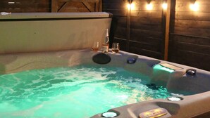 Een jacuzzi met bedieningspaneel en een glas.