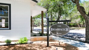 Naamplaatje voor The Briarpatch, opgericht in 2021, met een wit gebouw en een overdekt terras.