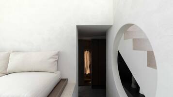 Un dormitorio moderno con una cama, un elemento decorativo circular en la pared y un pasillo que conduce a un armario.