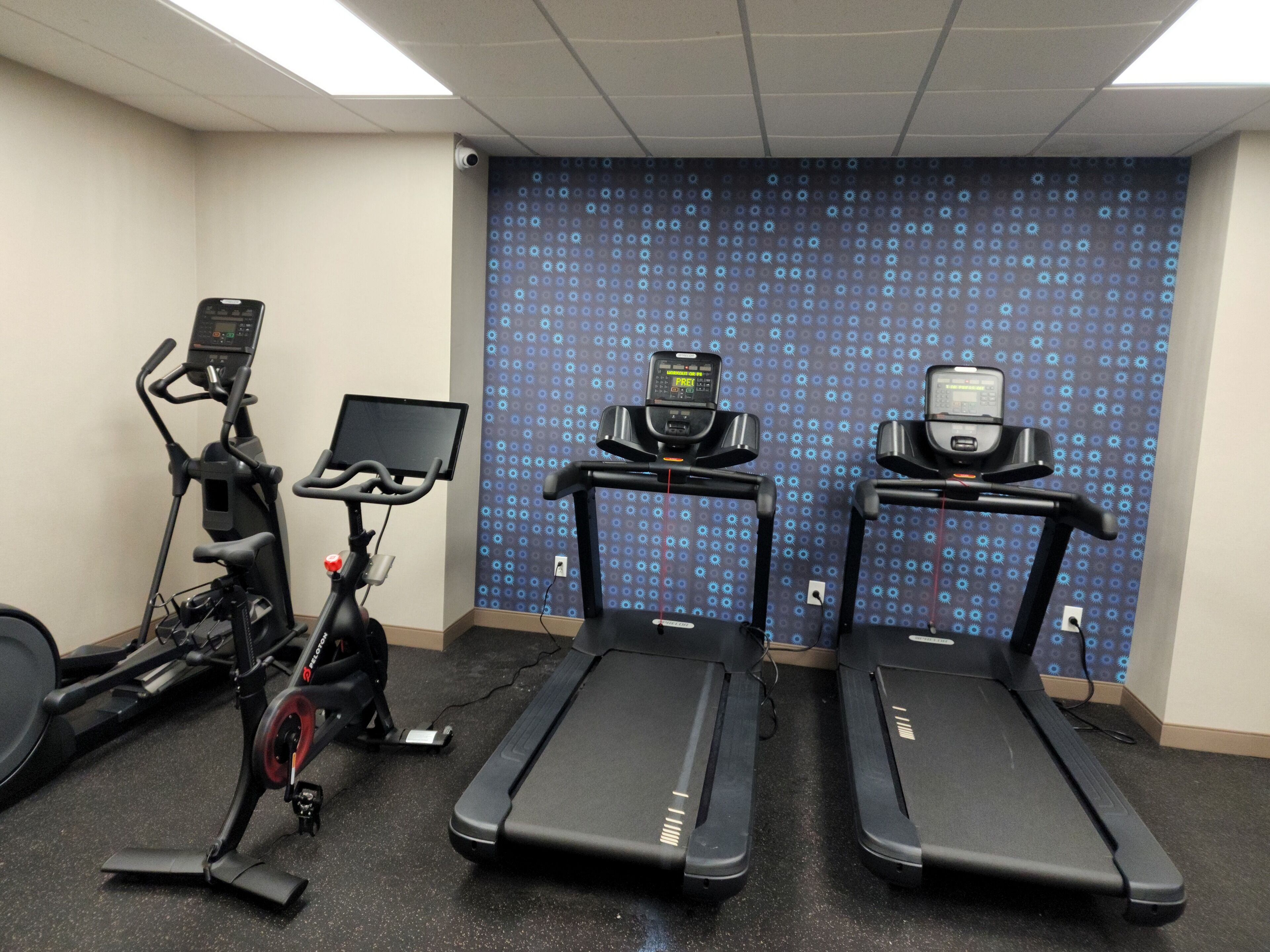 Et fitnessrum med løbebånd, crosstrainer og motionscykel.