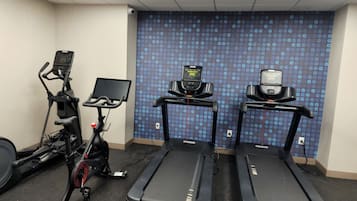 Et fitnessrum med løbebånd, crosstrainer og motionscykel.