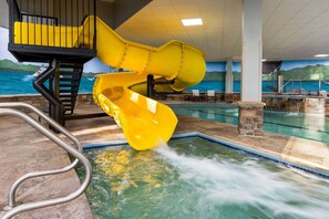 A pool area with a yellow water slide and a pool. - La Quinta Inn & Suites by Wyndham Lake George (Lake George)