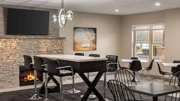 A conference room with a stone fireplace, a large table, and black chairs.