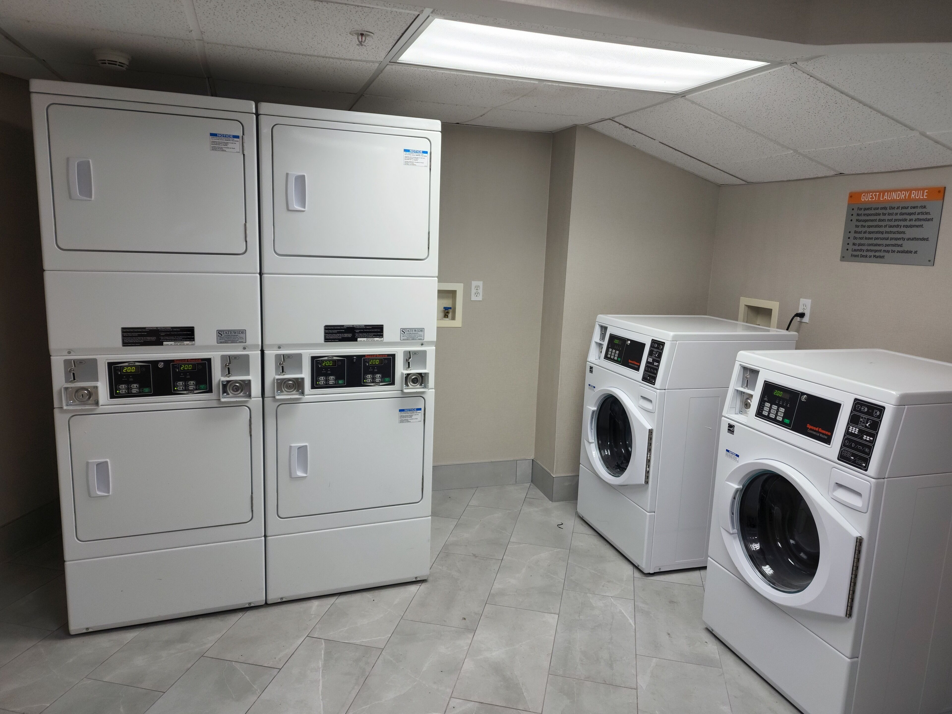 A laundry facility with stacked dryers and front-loading washers.