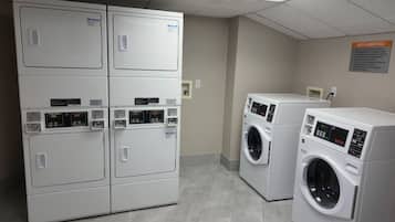 A laundry facility with stacked dryers and front-loading washers.