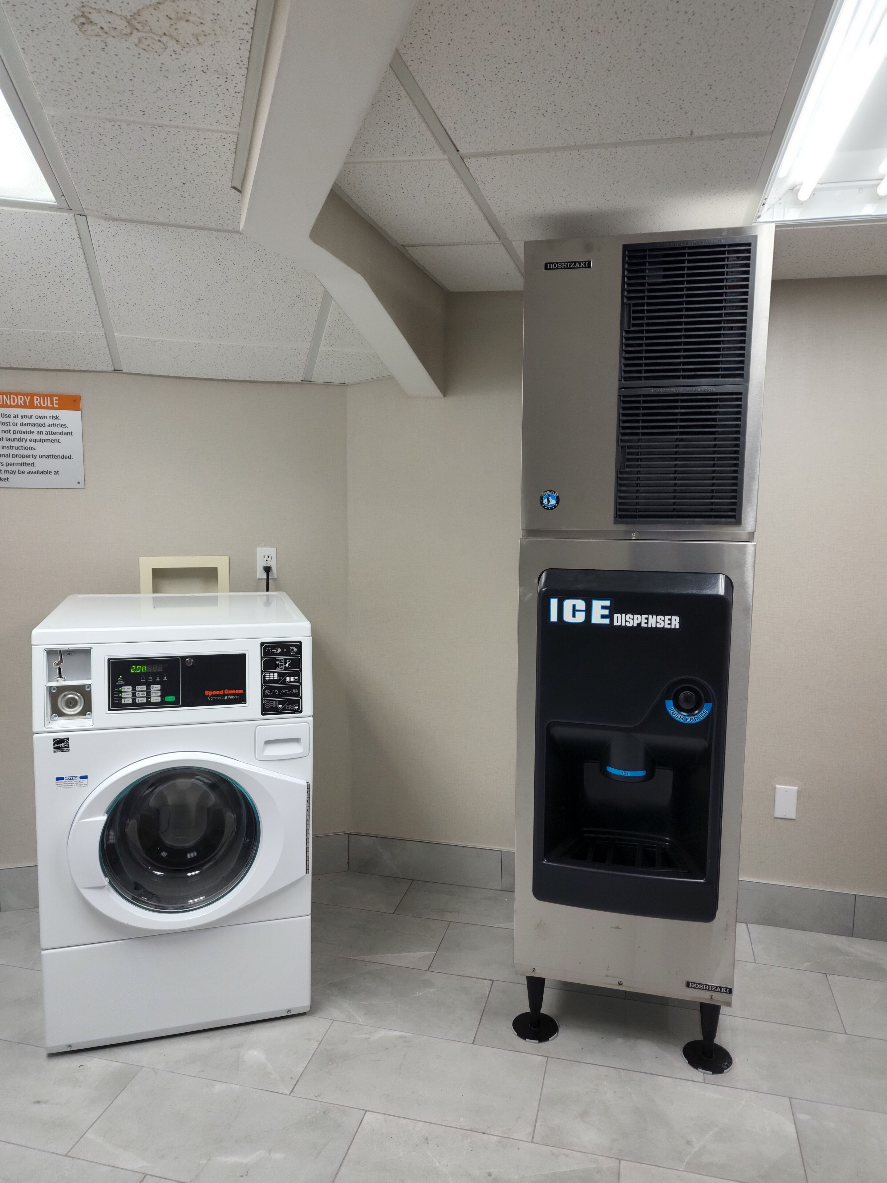 Een wasserij met een voorlader wasmachine en een ijsmachine.