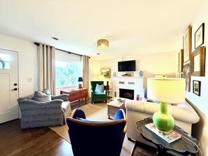 A living room with a fireplace, a television, and a sofa.