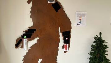 A large bear cutout on a wall, a small Christmas tree, and a sign with color codes.