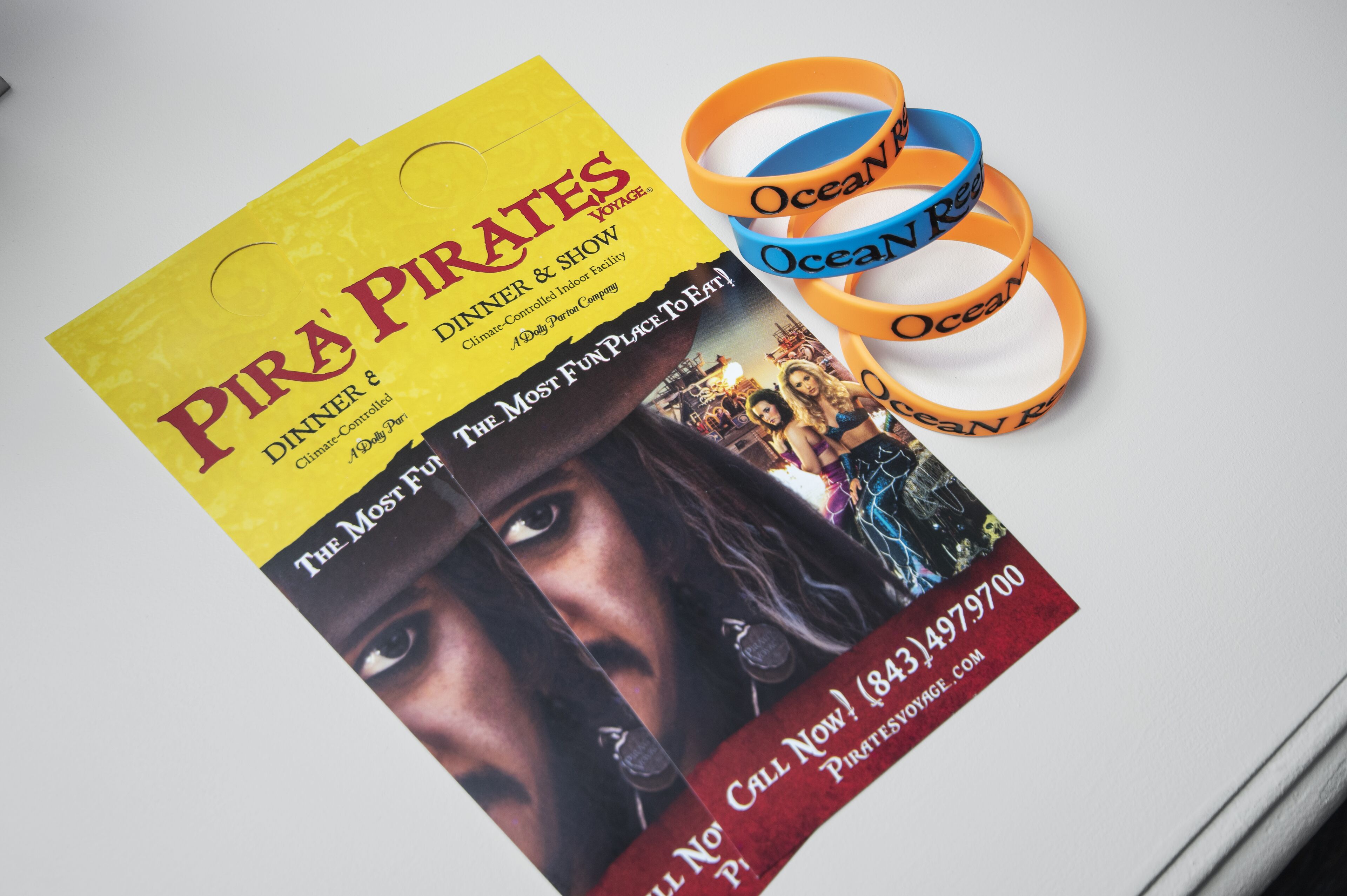 Une brochure promotionnelle pour le spectacle « Pirates Dinner & Show », avec un numéro de téléphone et une adresse de site web.
