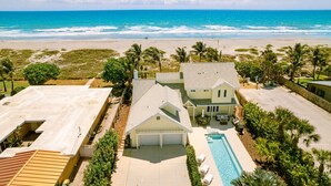 Une propriété située en bord de mer, dotée d’une piscine, d’un patio couvert et offrant une vue sur l’océan.