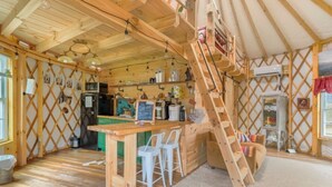 Une cuisine chaleureuse et rustique, avec des poutres en bois, une table en bois et des tabourets de bar.