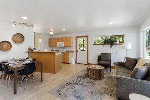 Uma cozinha moderna com armários de madeira, uma ilha central e um espaço de refeições com mesa e cadeiras.
