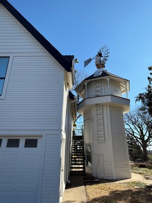 Ein weißes Gebäude mit einem Turm, gekrönt von einer Windmühle.
