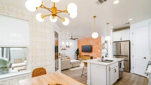 A modern kitchen with white cabinetry, a central island, and stainless steel appliances. - Eastside Oasis *Walk to Bars, Brews & Good Eats* (Austin)