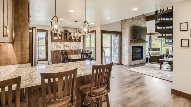 A spacious kitchen with a marble island, wooden chairs, and pendant lighting. - Ski-In Ski-Out, Skiwatch - Peak 8 Breckenridge, Sleeps 12  Newly Renovated (Breckenridge)