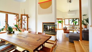 A spacious living area with a wooden dining table, comfortable seating, and large windows allowing natural light. - Spacious Designer Home in Boulder Perfect for Families and Groups (Boulder)