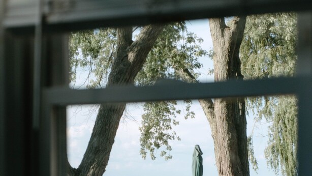 A view from inside a room looking out to a patio with a table, chairs, and a green umbrella. - River & Bay Views! Shirley’s Temple! BAY CITY, MI (Bay City)