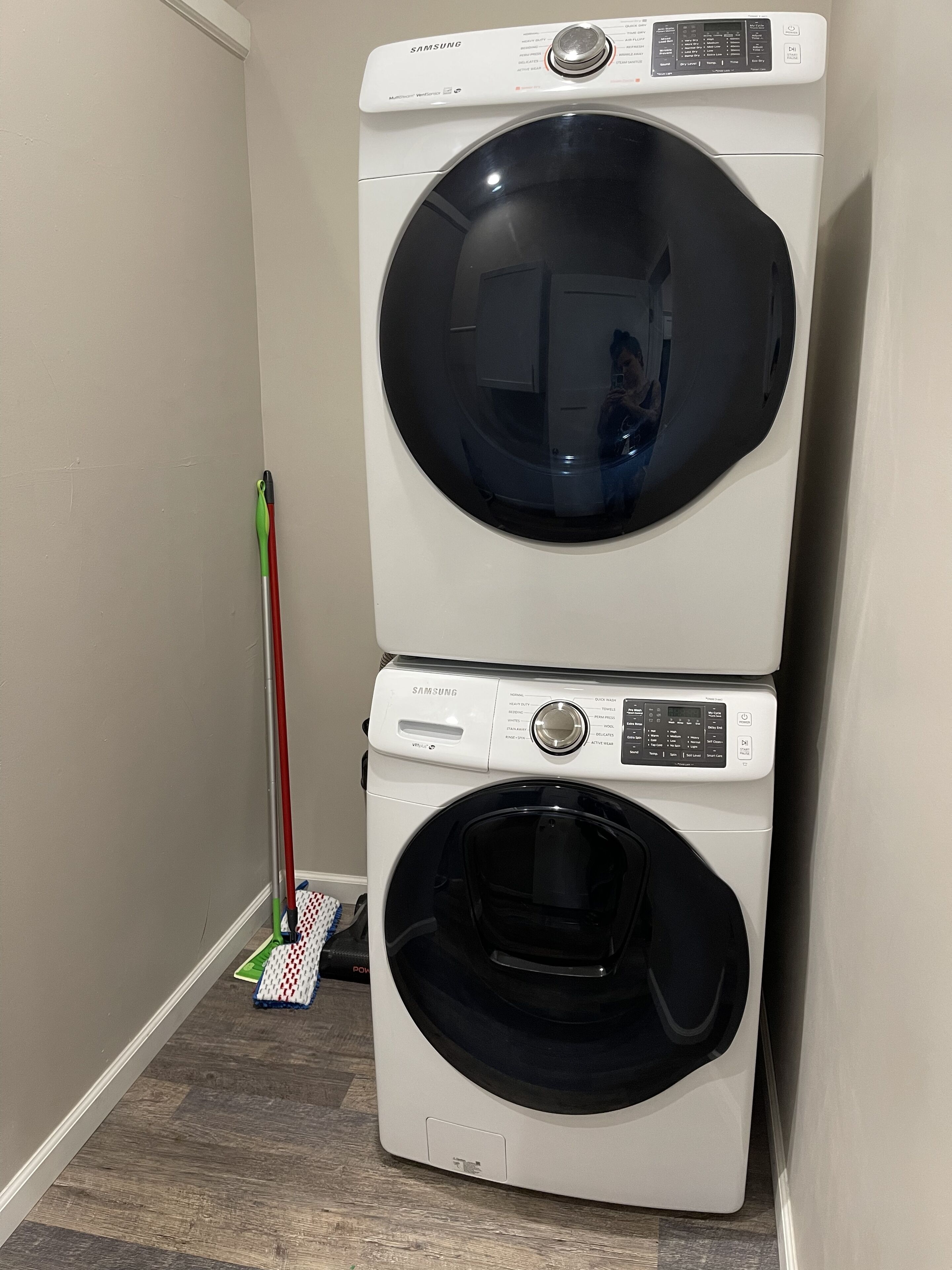 A stacked washer and dryer unit in a laundry room.