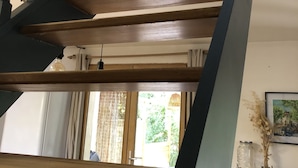 Una escala de fusta amb barana fosca i un rerapeig, que porta a un pis superior.