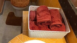 A bathroom with a toilet, a shower, and a basket of towels. - Villa within walking distance to the beach!!! (Saly)