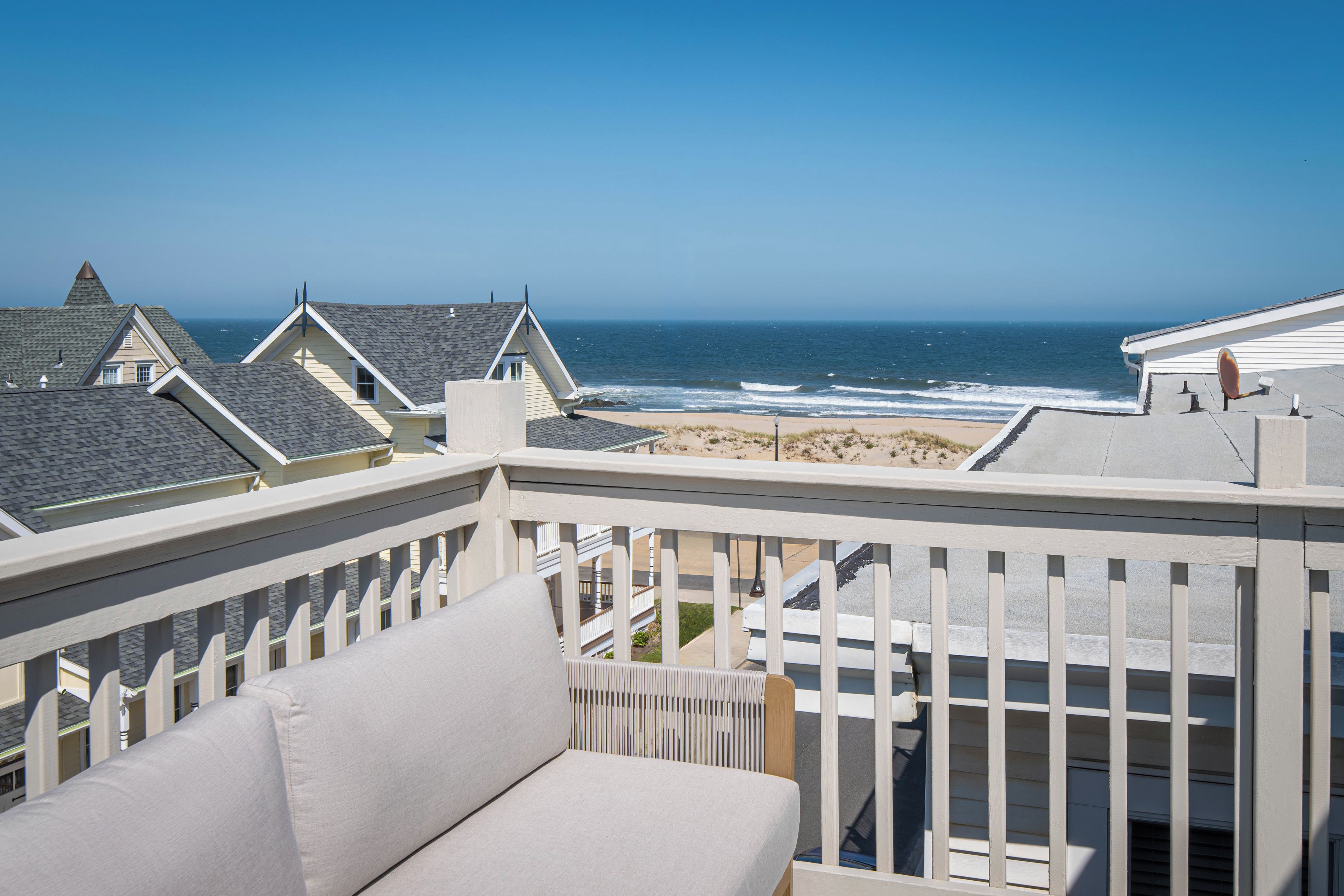 A balcony with a view of the ocean and beach.