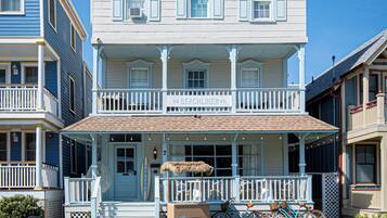 A two-story building with a porch, a bicycle parked in front, and a sign that reads 'The Beachliner.'
