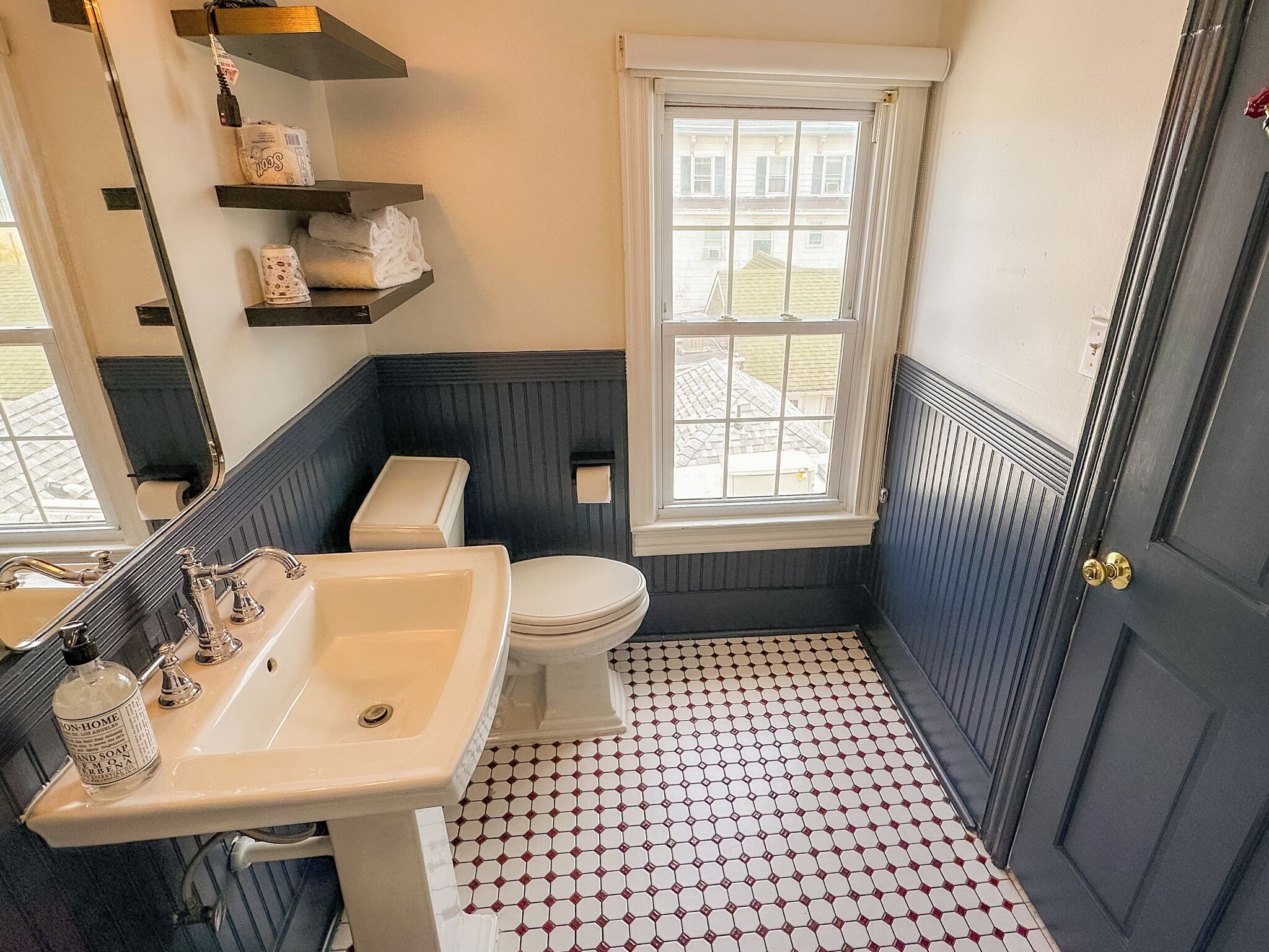 Un baño con lavamanos blanco, inodoro y ventana.