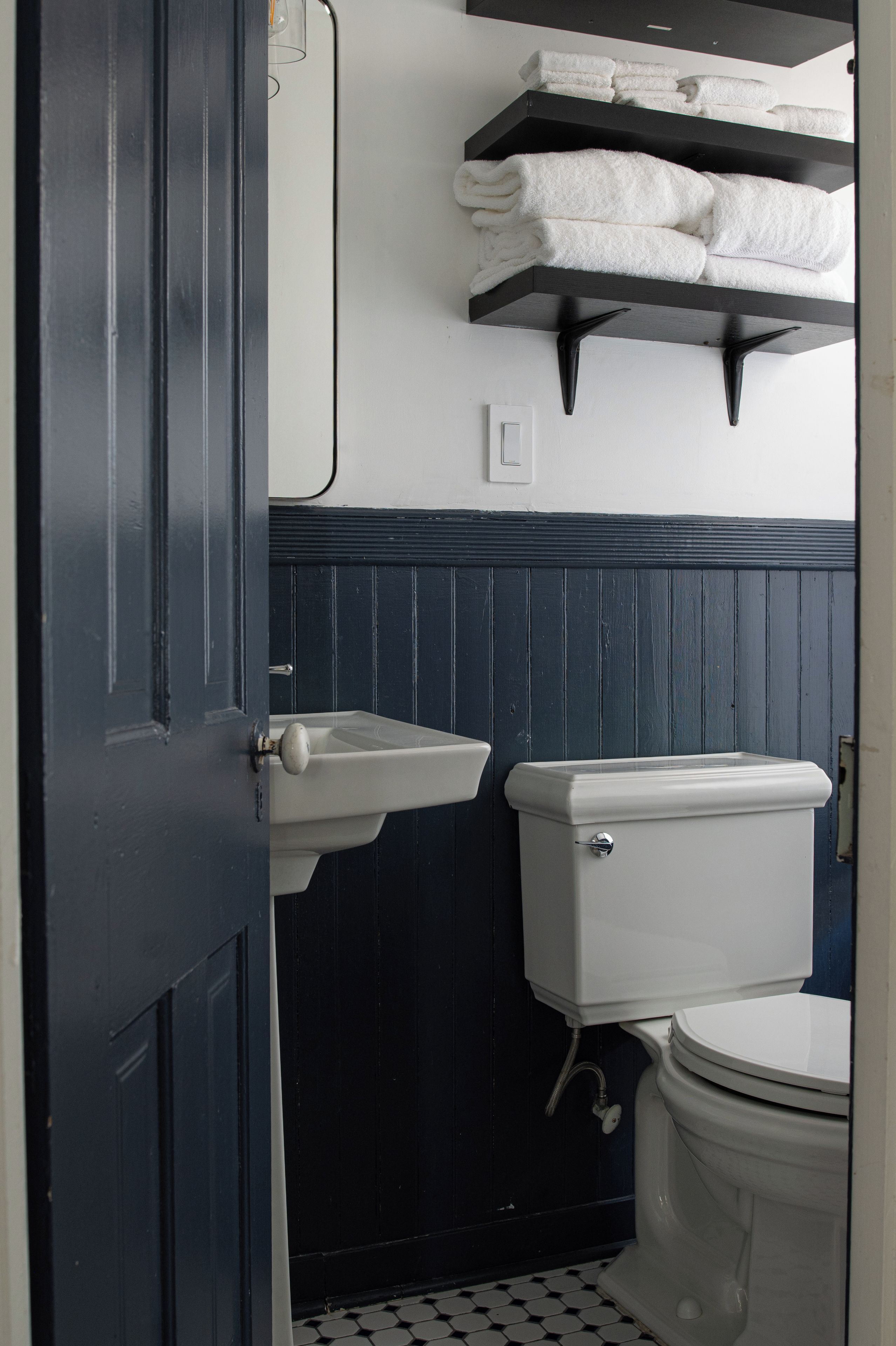 A bathroom with a toilet, a sink, and a towel rack.
