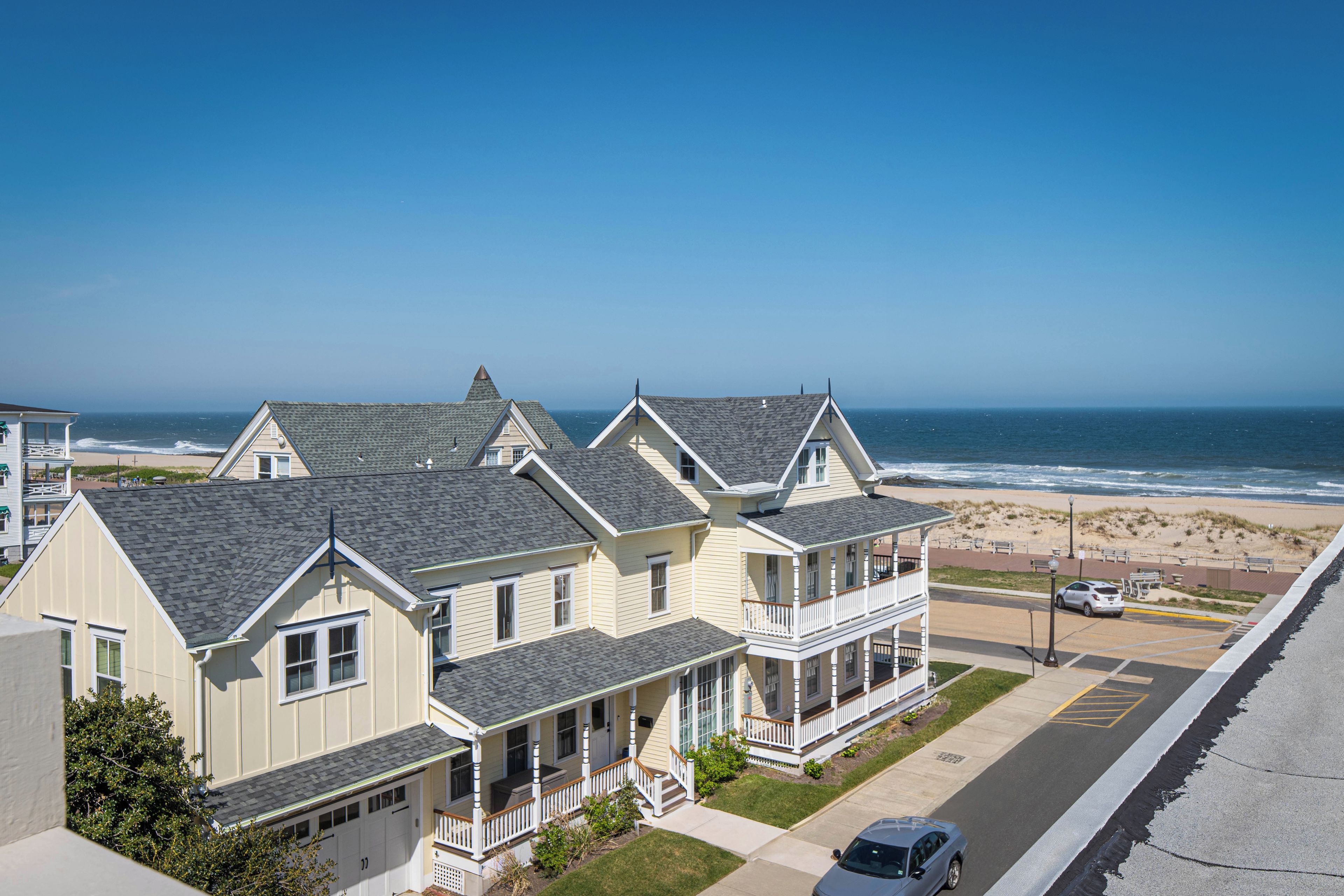 A coastal residential area with houses featuring gabled roofs and a view of the ocean.