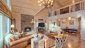 A spacious living room with a fireplace, leather sofas, and a wooden ceiling. - Sunset Mountain Views- Spacious Luxurious cabin (Morganton)