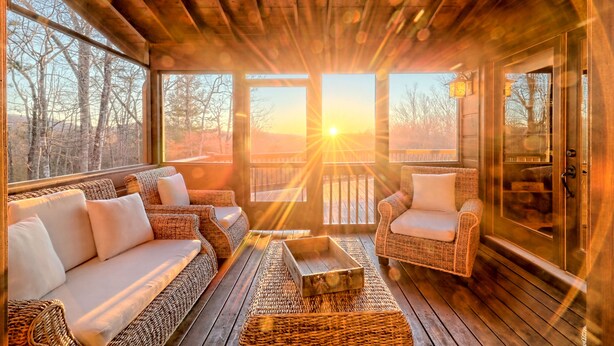 A cozy wooden deck with wicker furniture and a view of the sunset. - Sunset Mountain Views- Spacious Luxurious cabin (Morganton)