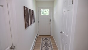 A narrow hallway with a wooden floor, white walls, and a door at the end. - Detox & Hike: Waterfront Oasis with Infrared Sauna & Shawangunk Mountains (wallkill)