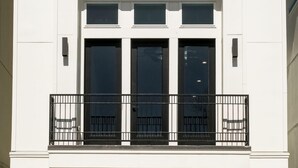 A modern building with a white facade, a central entrance with double doors, and a garage door. - Elegant Lux Townhome. 3BD, 3.5BTH. DOWNTOWN HTX (Houston)