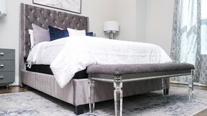 A modern bedroom with a tufted headboard, a grey bench, and a patterned rug. - Elegant Lux Townhome. 3BD, 3.5BTH. DOWNTOWN HTX (Houston)