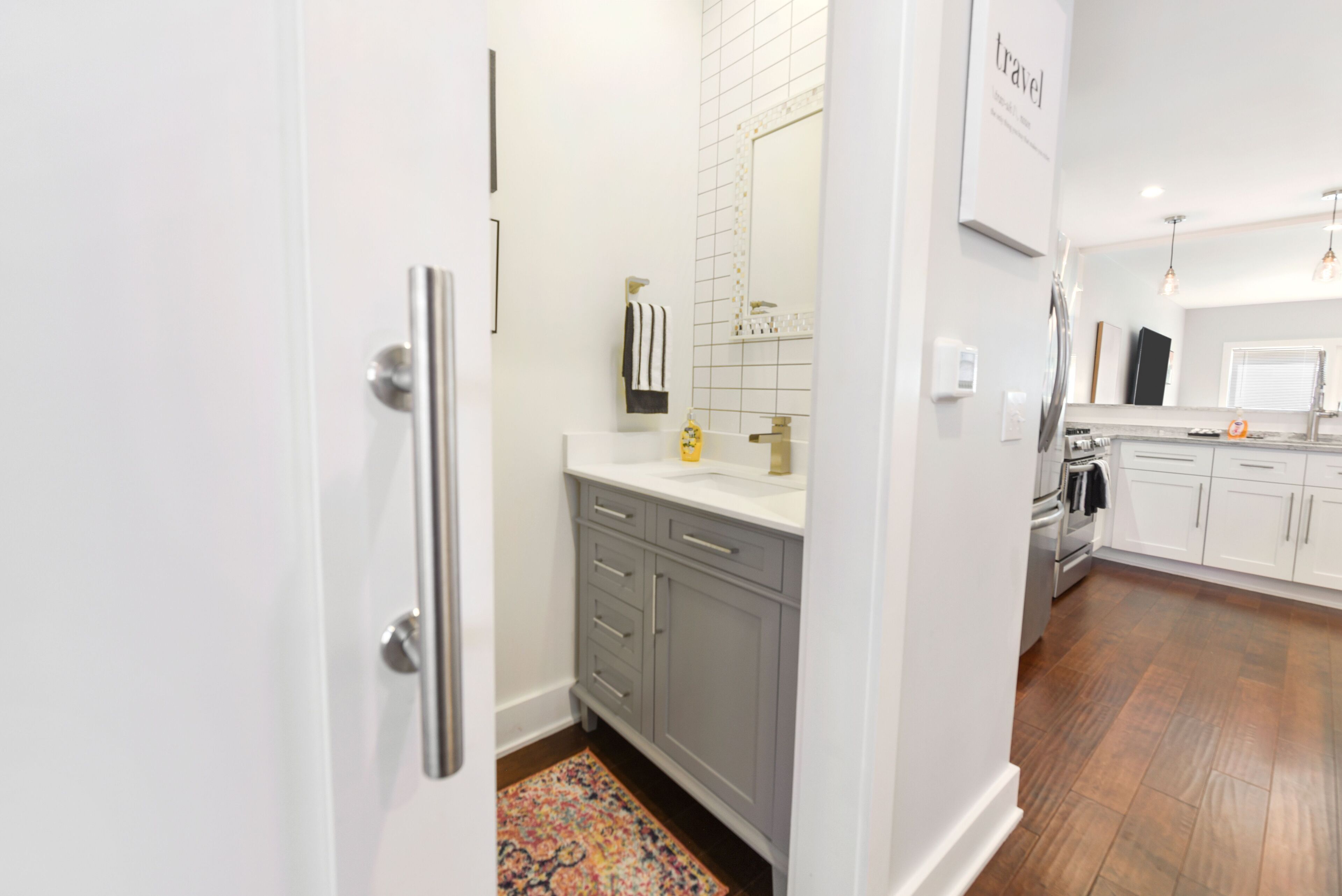 A modern bathroom with a large mirror, a towel rack, and a sink.
