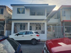 Un bâtiment à deux étages, doté de fenêtres grillagées et d’une entrée fermée par un portail.