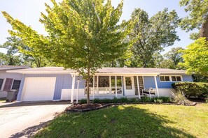 A single-story house with a garage, a covered porch, and a small yard with a tree. - Blue Chill | WalktoBeach | HotTub-all yr | Dogs OK (Michigan City)