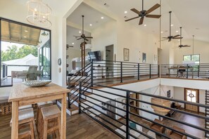 A spacious interior with a high ceiling, multiple levels, and a central staircase.