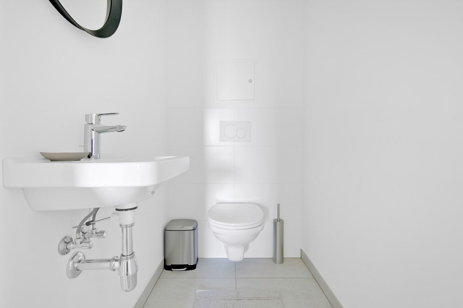 Une salle de bain moderne avec un lavabo blanc, un robinet chromé et des toilettes.