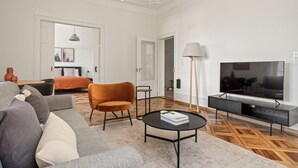 A modern living room with a sofa, armchair, coffee table, TV, and floor lamp. - Weinegg 4.5 Room w/ Storage & W/D, 2 mins to Mkt (Zurich)