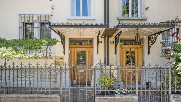 A building with two numbered doors, a wrought iron fence, and a small garden area with potted plants. - Weinegg 4.5 Room w/ Storage & W/D, 2 mins to Mkt (Zurich)