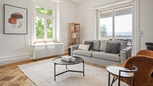 A modern living room with a grey sofa, a coffee table, and a bookshelf. - Weinegg 4.5 Room w/ Storage & W/D, 2 mins to Mkt (Zurich)