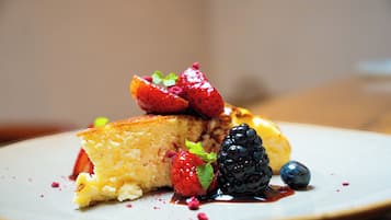 A dessert plate with a slice of cake, strawberries, and blueberries.