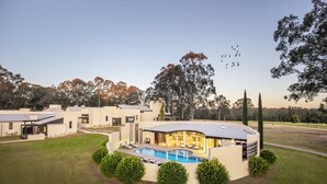 A modern residential complex with a swimming pool, lounge area, and multiple houses. - Tower Lodge (Pokolbin)