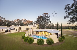 Un complejo residencial moderno con piscina, zona de estar y varias casas.