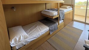 Ein Mehrbettzimmer mit Schiebetür zum Außenbereich.