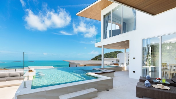 A modern house with a large swimming pool, outdoor seating, and a view of the sea. - Villa the wave (Koh Samui)